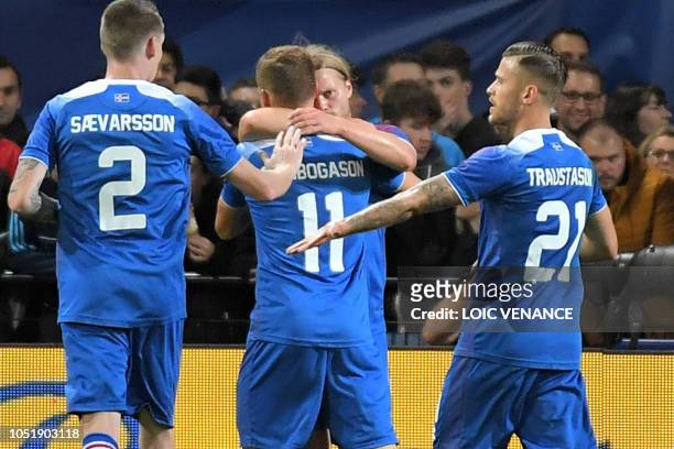 Iceland's midfielder Birkir Bjarnason celebrates with teammates after scoring a goal during the friendly football match between France and Iceland at...