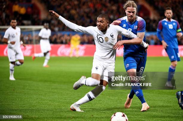 France's forward Kylian Mbappe vies with Iceland's midfielder Birkir Bjarnason during the friendly football match between France and Iceland at the...