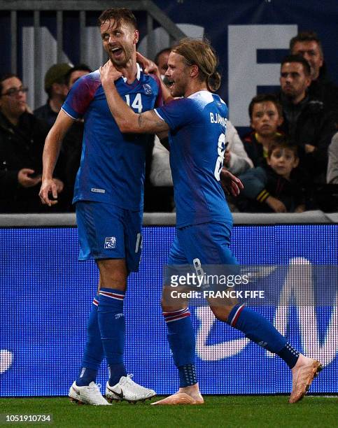 Iceland's midfielder Kari Arnason celebrates his goal with his teammate Iceland's midfielder Birkir Bjarnason during the friendly football match...
