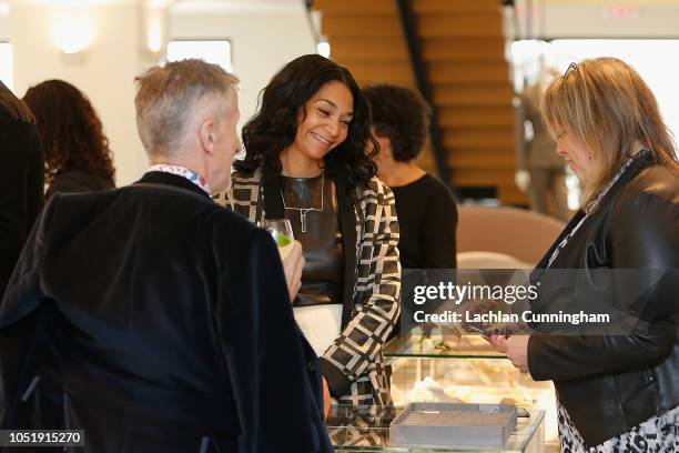 Monique Pean shows her jewelry to guests during a celebration in support of UCSF Benioff Children's Hospital at Freds at Barneys New York on October...