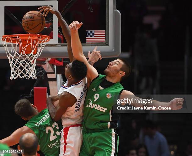 Shai Gilgeous-Alexander of the Los Angeles Clippers gets past Daniel Koperberg and Roman Sorkin of Maccabi Haifa for a dunk in the second half of the...