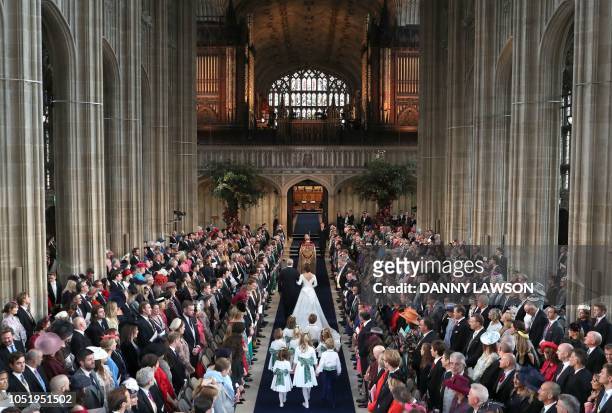 Britain's Princess Eugenie of York accompanied by her father Britain's Prince Andrew, Duke of York, walk up the aisle during her wedding ceremony to...