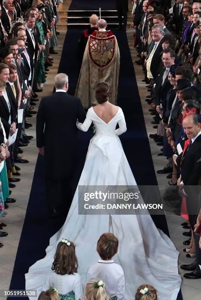 Britain's Princess Eugenie of York accompanied by her father Britain's Prince Andrew, Duke of York, walk up the aisle during her wedding ceremony to...