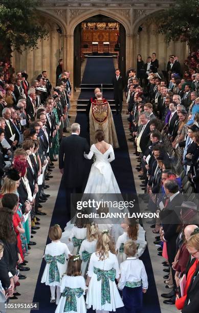 Britain's Princess Eugenie of York accompanied by her father Britain's Prince Andrew, Duke of York, walk up the aisle during her wedding ceremony to...