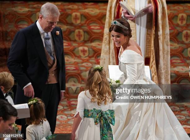 Britain's Princess Eugenie of York accompanied by her father Britain's Prince Andrew, Duke of York, walks up the aisle during her wedding ceremony to...