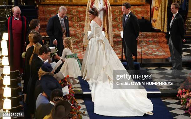 Britain's Princess Eugenie of York accompanied by her father Britain's Prince Andrew, Duke of York, walks up the aisle during her wedding ceremony to...