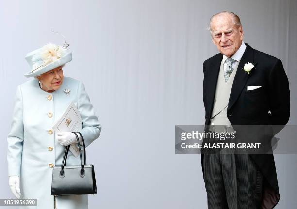 Britain's Queen Elizabeth II and Britain's Prince Philip, Duke of Edinburgh wait for the carriage carrying Princess Eugenie of York and her husband...
