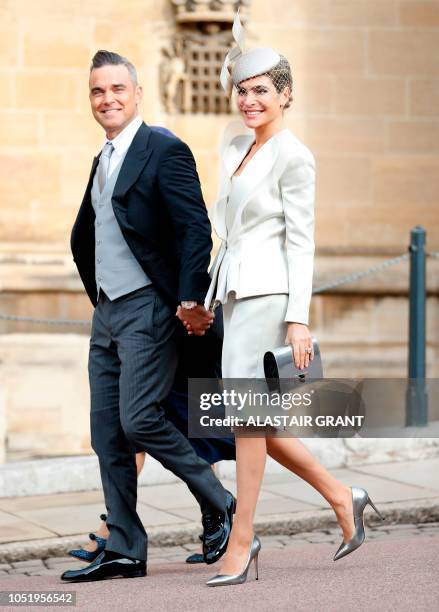 British singer-songwriter Robbie Williams arrives with his wife US actress Ayda Field to attend the wedding of Britain's Princess Eugenie of York to...