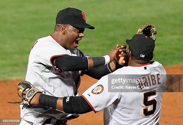 Edgar Renteria and Juan Uribe of the San Francisco Giants celebrate after they defeated the Atlanta Braves 3-2 during Game Four of the NLDS of the...