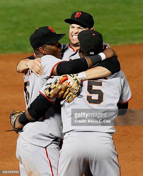 Edgar Renteria, Freddy Sanchez and Juan Uribe of the San Francisco Giants celebrate after they defeated the Atlanta Braves 3-2 during Game Four of...