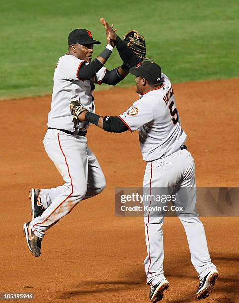 Edgar Renteria and Juan Uribe of the San Francisco Giants celebrate after they defeated the Atlanta Braves 3-2 during Game Four of the NLDS of the...