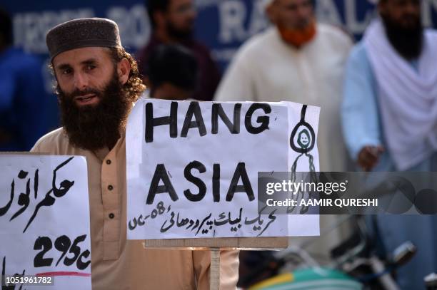 Supporter of Tehreek-e-Labaik Pakistan , a hardline religious political party holds a placard during a protest in Rawalpindi on October 12 demanding...