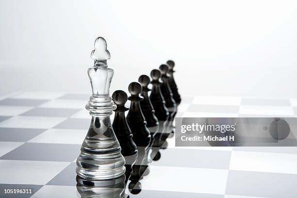 white pawns that queues up behind black king - spelregels stockfoto's en -beelden
