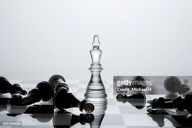 black chessman knocked down by white king - rivaliteit stockfoto's en -beelden