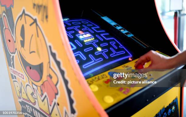 October 2018, Berlin: 12 October 2018, Germany, Berlin: A young man plays Pac-Man at an arcade vending machine at the edge of construction for the...