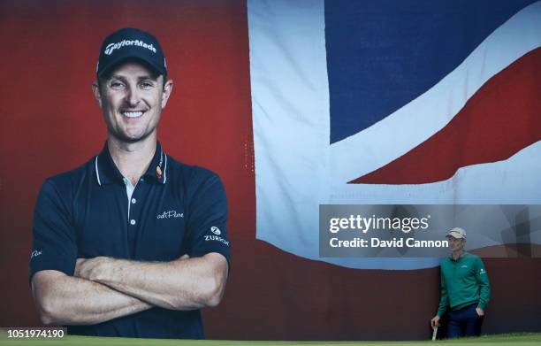 Justin Rose of England the host of the tournament waits beside a large mural of his portrait behind the 18th green during the second round of the Sky...