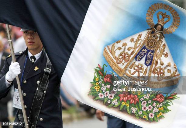 Faithful carries a flag with the image of the Virgin of Zapopan, during the annual pilgrimage towards the Cathedral of Zapopan, in Zapopan, state of...