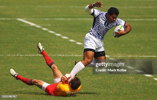 Ofisa Treviranus of Samoa is tackled by Ben Gollings of England during the rugby 7's quarter final match between England and Samoa at Delhi...