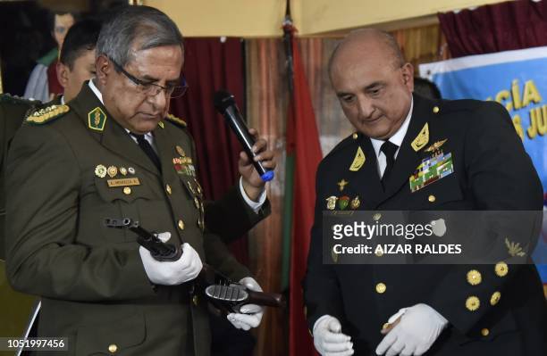 Bolivian police commander Alfonso Mendoza holds a rifle handed over to him by Peruvian National Police commander Richard Douglas Zubiate in the...
