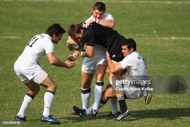 Tim Mikkelson of New Zealand is tackled during the rugby 7's semifinal match between New Zealand and England at Delhi University during day nine of...