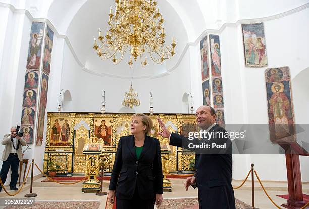 In this photo provided by the German Government Press Office, Romanian President Traian Basescu shows German Chancellor Angela Merkel art in the...