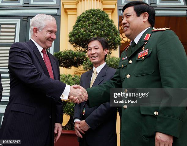 Defence Secretary Robert Gates and Vietnamese Minister of Defense General Phung Quang Thanh shake hands outside the Presidential Palace as they...