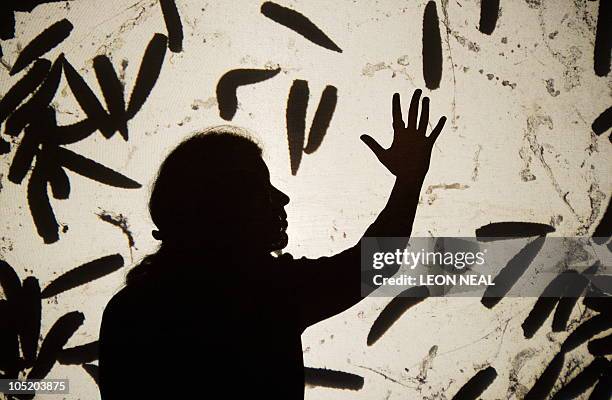 Woman poses with a projection of live maggots on a screen, in Paul Insect's "Maggot Planet" installation, at the "Hell's Half Acre" exhibition at the...