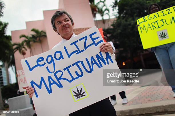 Florida Attorney General candidate Jim Lewis, who is running on a platform of legalizing marijuana, holds a sign during a campaign rally on October...