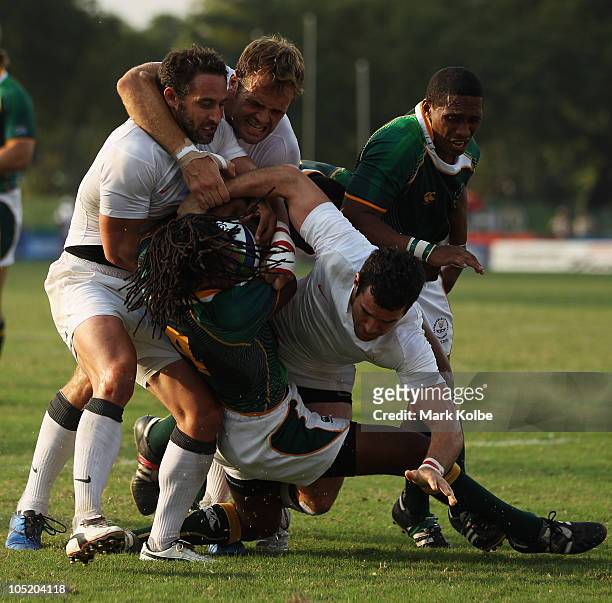 Cecil Africa of South Africa is tackled during the rugby 7's Bronze Medal match between England and South Africa at Delhi University during day nine...