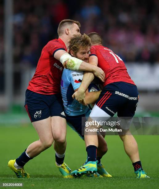 Gareth Steenson of Exeter Chiefs is tackled by Rory Scannell and Andrew Conway of Munster during the Heineken Champions Cup match between Exeter...