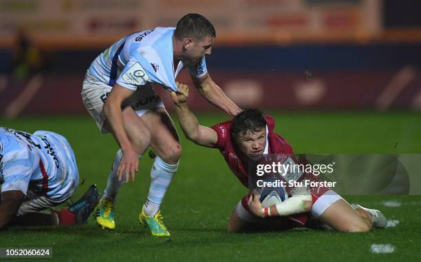 Racing fly half Finn Russell gets to grips with Scarlets wing Steffan Evans during the Champions Cup match between Scarlets and Racing 92 at Parc y...