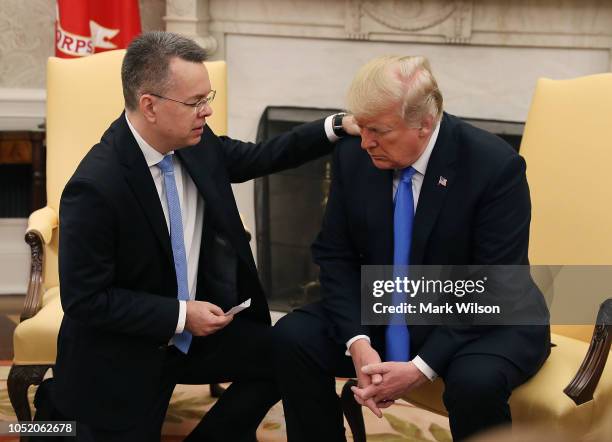 President Donald Trump and American evangelical Christian preacher Andrew Brunson participate in a prayer in the Oval Office a day after he was...