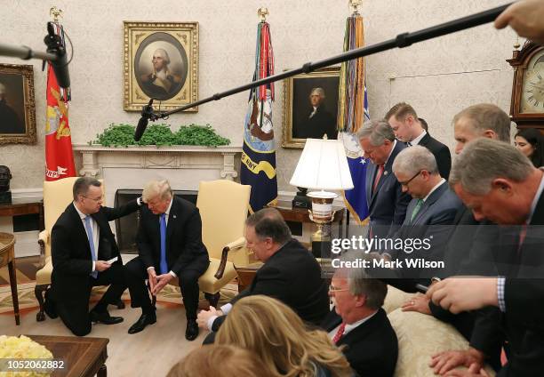 Flanked by members of Congress and administration officials, U.S. President Donald Trump and American evangelical Christian preacher Andrew Brunson...