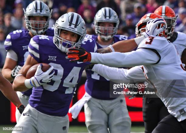 Running back Alex Barnes of the Kansas State Wildcats runs up field against pressure from linebacker Kenneth Edison-McGruder of the Oklahoma State...