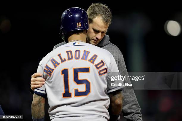 Martin Maldonado of the Houston Astros is checked by the trainer after being hit by a pitch during the second inning against the Boston Red Sox in...