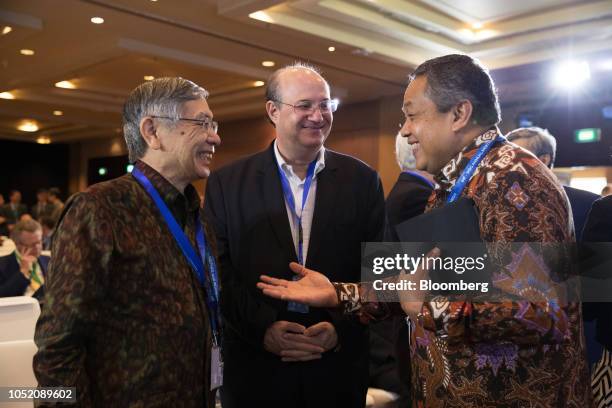 Perry Warjiyo, governor of Bank Indonesia, right, speaks with Ilan Goldfajn, president of the Central Bank of Brazil, center, and Haruhiko Kuroda,...