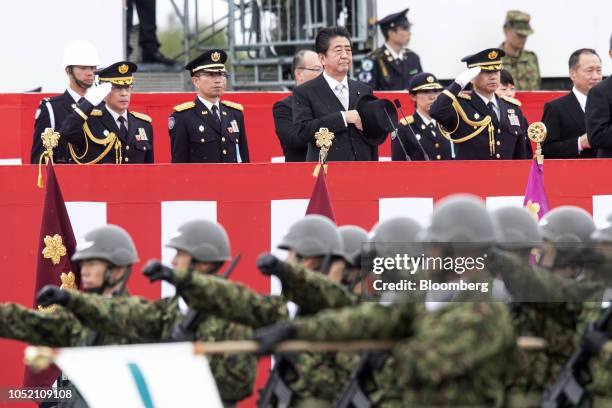 Shinzo Abe, Japan's prime minister, center, reviews troops of the Japan Self Defense Forces at Japan Ground Self-Defense Force Camp Asaka in Asaka,...