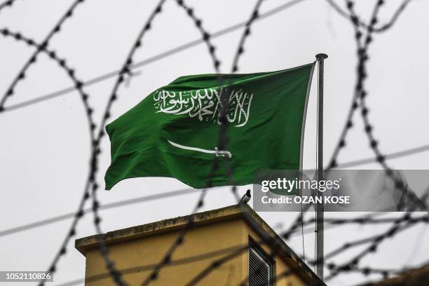 The Saudi Arabian flag is seen behind barbed wire as it flies on the roof at the Saudi Arabian consulate in Istanbul on October 14, 2018. - Turkey on...