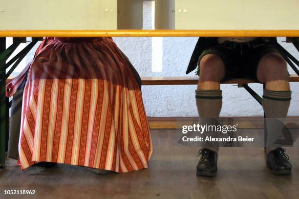 Voters wearing traditional Bavarian lederhosen and dirndls cast their ballots in Bavarian state elections on October 14, 2018 in Osterwarngau,...