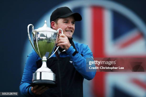 Eddie Pepperell of England pose for a photo with the trophy after winning the tournament during day four of Sky Sports British Masters at Walton...