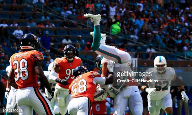 Danny Amendola of the Miami Dolphins is flipped by Leonard Floyd and Roquan Smith of the Chicago Bears in the first quarter of the game at Hard Rock...