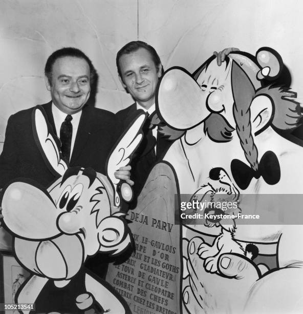 The French Scriptwriter Rene Goscinny And Illustrator Albert Uderzo Holding A Huge Drawing Of The Comic-Strip Heroe Asterix, One Of Its Adventure Was...