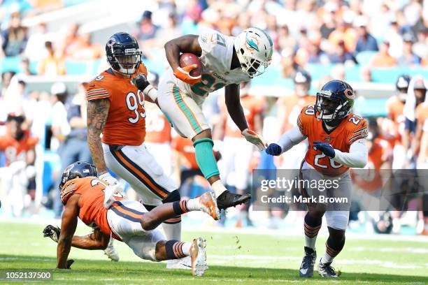 Frank Gore of the Miami Dolphins jumps over the defense of Adrian Amos of the Chicago Bears in the second half of the game at Hard Rock Stadium on...