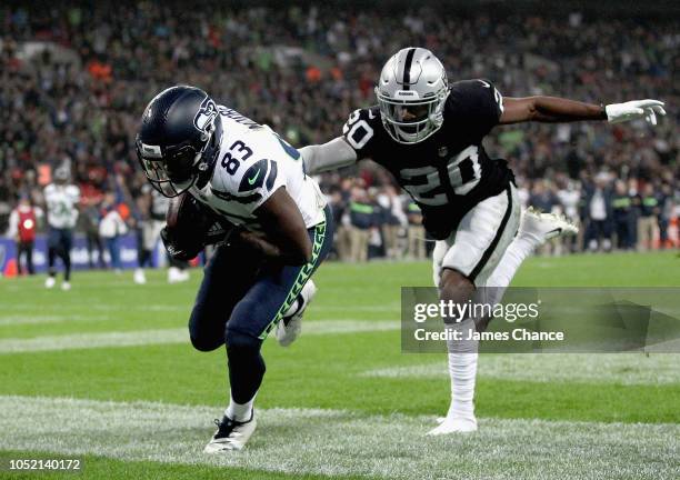 David Moore of Seattle Seahawks scores a touchdown as Daryl Worley of Oakland Raiders attemptst to tackle him during the NFL International series...