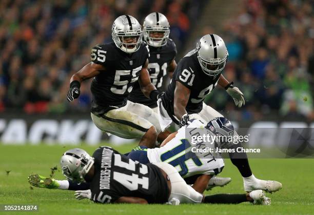 Tyler Lockett of Seattle Seahawks is tackled by Dominique Rodgers-Cromartie of Oakland Raiders and Shilique Calhoun of Oakland Raiders during the NFL...