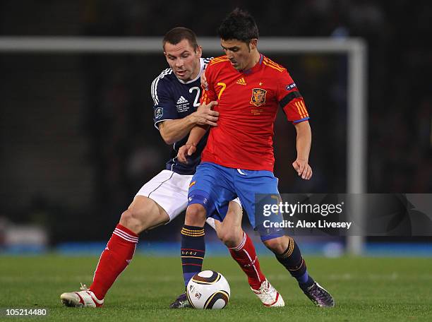 David Villa of Spain holds off a challenge from Phil Bardsley of Scotland during the UEFA EURO 2012 Group I Qualifier match between Scotland and...