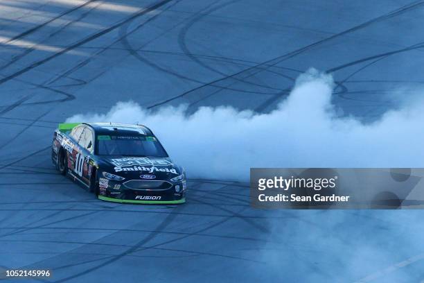 Aric Almirola, driver of the Smithfield Bacon for Life Ford, celebrates with a burnout after winning the Monster Energy NASCAR Cup Series...