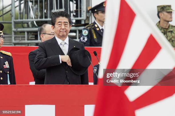 Shinzo Abe, Japan's prime minister, salutes as he reviews troops of the Japan Self-Defense Forces at the Japan Ground Self-Defense Force Camp Asaka...