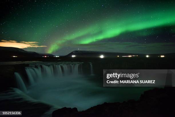 The aurora borealis, also known as Northern Lights, is seen over Godafoss waterfall, in the municipality of Thingeyjarsveit, east of Akureyri, in...