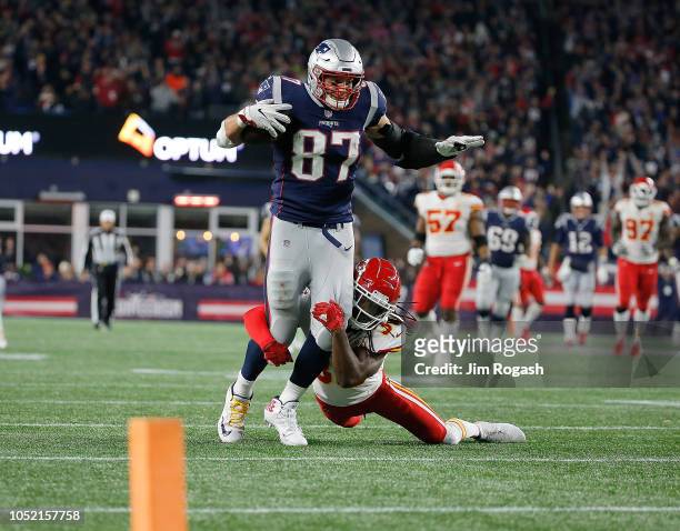 Rob Gronkowski of the New England Patriots runs the ball after making a catch as Josh Shaw of the Kansas City Chiefs defends in the fourth quarter at...